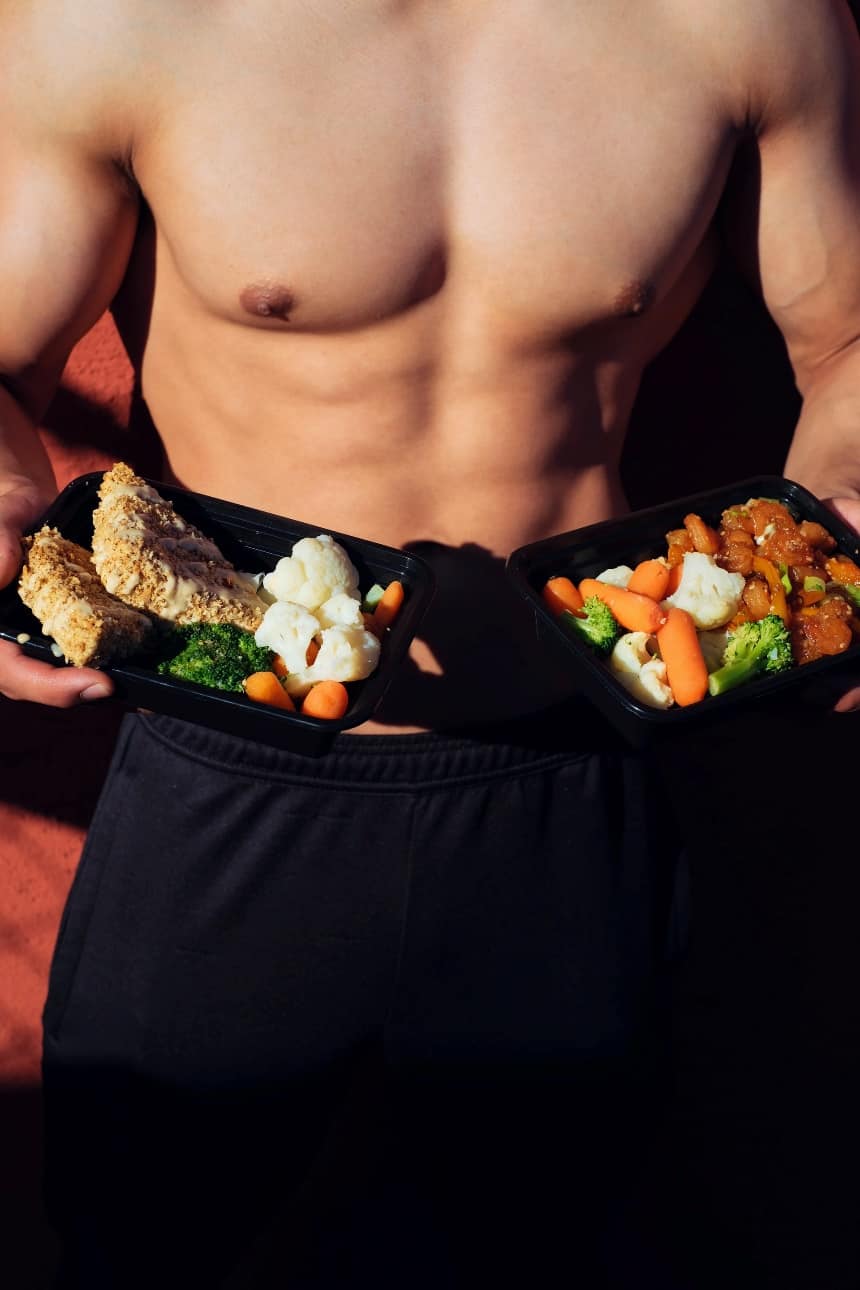 Physically fit man carrying a plate of healthy food