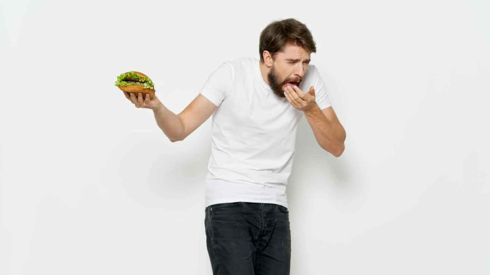 man holding burger disgusted