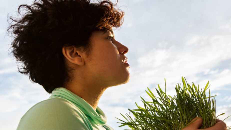 a young man holding grass