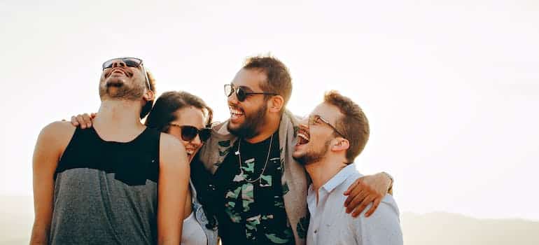 four friends embracing each other and cultivating positive relationships
